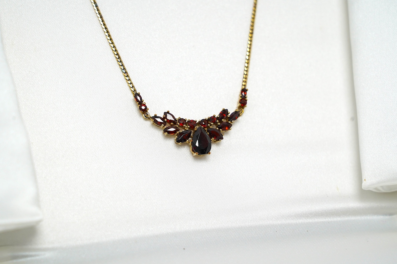 A modern 9ct gold and garnet cluster set necklace, 41cm, gross weight 6.4 grams. Condition - good